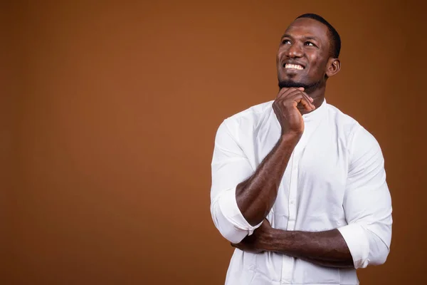 Retrato del guapo empresario africano sobre fondo marrón —  Fotos de Stock