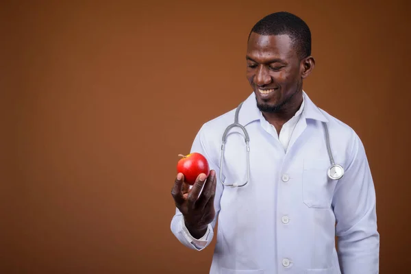 Guapo africano hombre médico contra marrón fondo —  Fotos de Stock