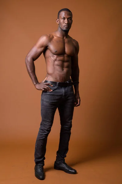 Bonito muscular Africano homem sem camisa contra fundo marrom — Fotografia de Stock