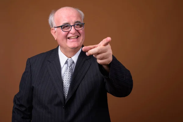 Uomo d'affari anziano in sovrappeso che indossa occhiali contro marrone b — Foto Stock