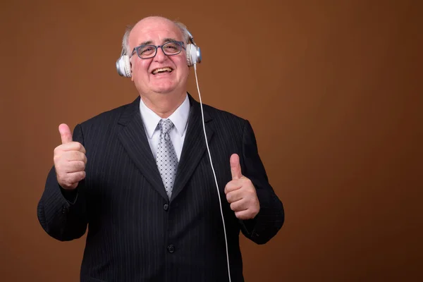 Overweight senior uomo d'affari ascoltare musica con le cuffie — Foto Stock