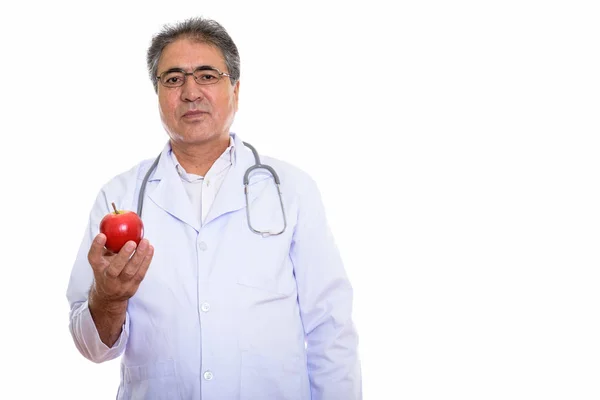 Captura de estudio de un médico persa mayor sosteniendo manzana roja — Foto de Stock