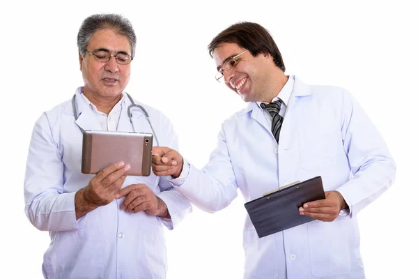 Estudio toma de feliz joven y mayor persa hombre médico sonriendo — Foto de Stock