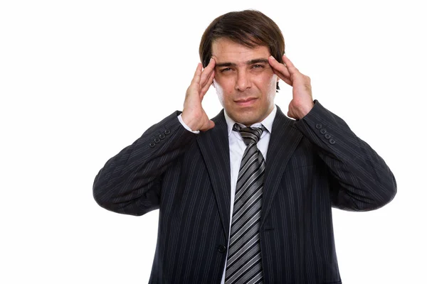 Studio shot of young stressed Persian businessman having headach Stock Image