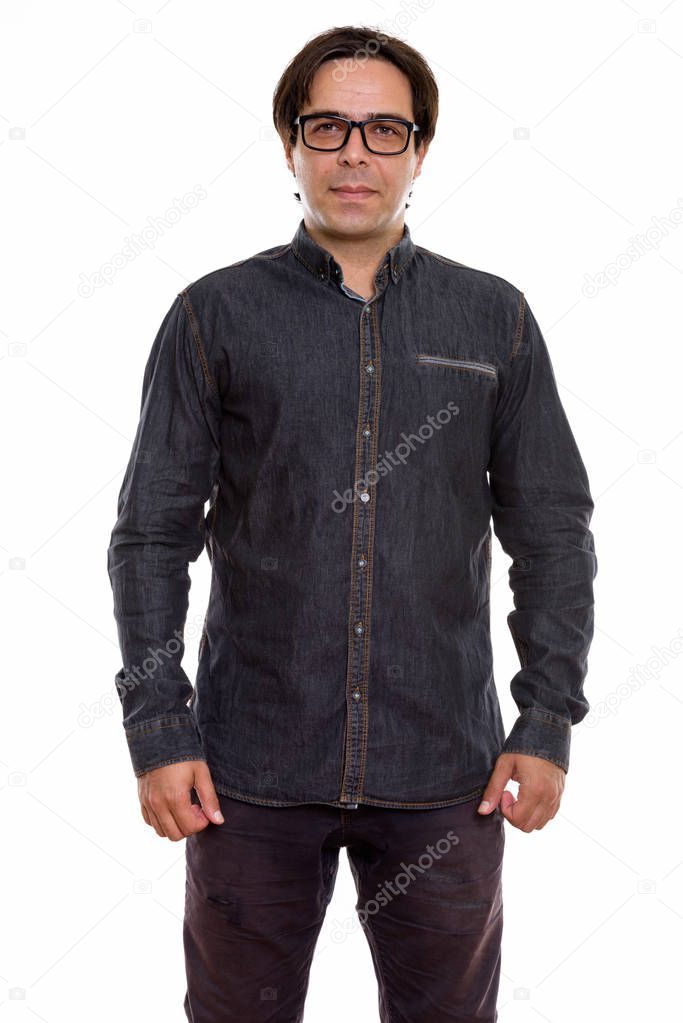 Studio shot of young Persian man standing and wearing eyeglasses