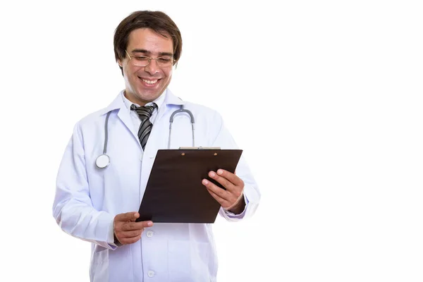 Estúdio tiro de jovem feliz persa homem médico sorrindo enquanto lido — Fotografia de Stock