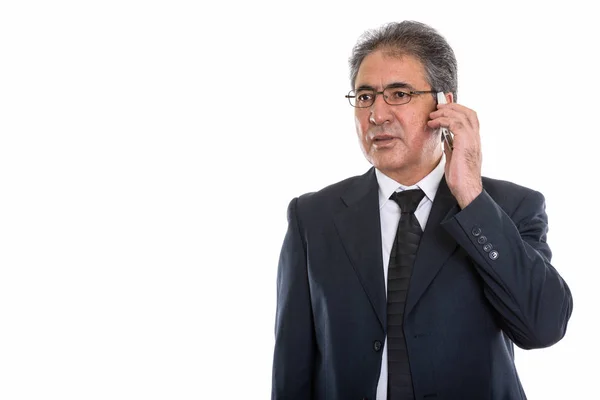 Studio shot van senior Perzisch zakenman praten op mobiele phon — Stockfoto