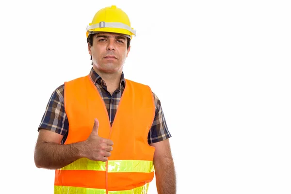 Studio shot of young Persian man construction worker giving thum — Stock Photo, Image