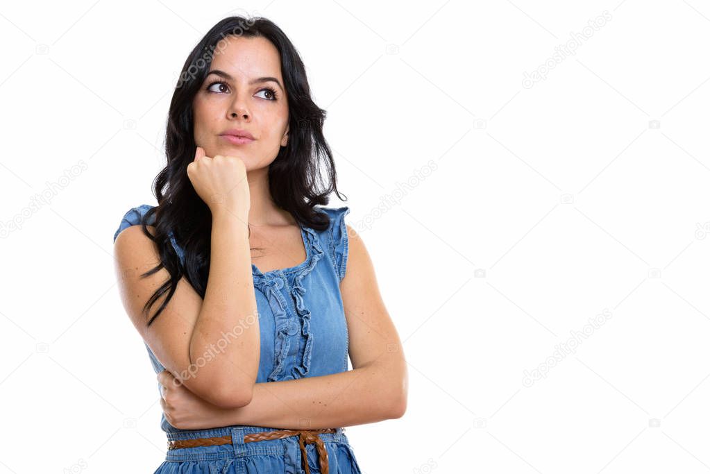 Studio shot of young beautiful Spanish woman thinking while look