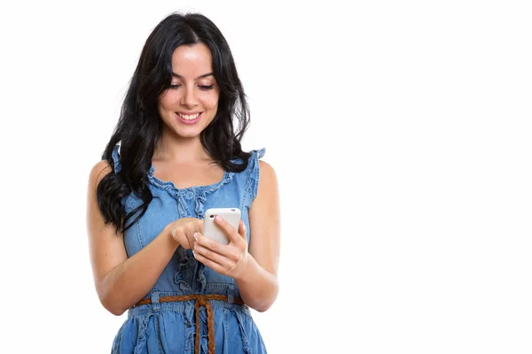 Studio shot of young happy Spanish woman smiling while using mob — Stock Photo, Image