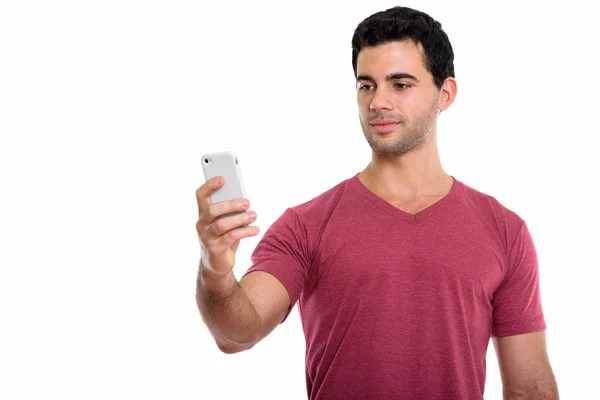 Captura de estudio de joven apuesto hombre hispano usando teléfono móvil —  Fotos de Stock