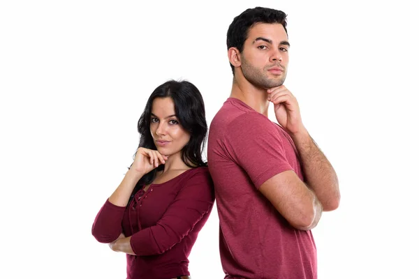 Estúdio tiro de jovem casal pensando em conjunto com costas para trás — Fotografia de Stock