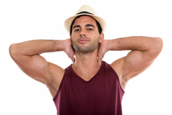 Studio shot of young handsome Hispanic man with both arms behind — Stock Photo, Image