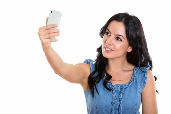 Studio shot of young happy Spanish woman smiling while taking se Royalty Free Stock Photos