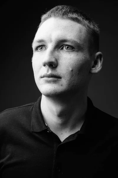 Молодий чоловік на чорному тлі в чорно-білому — стокове фото