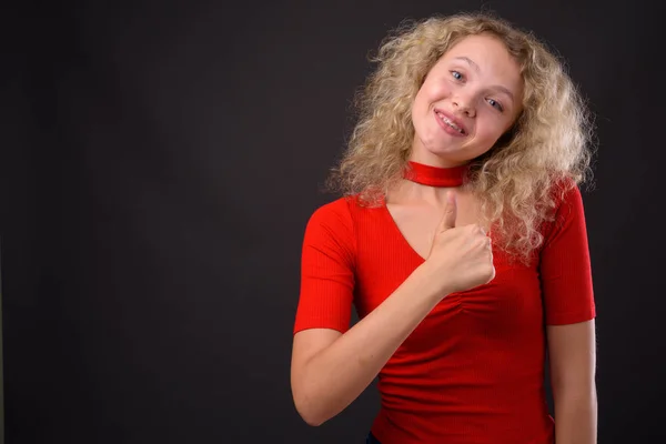 Jovem mulher bonita com cabelo encaracolado loiro contra backgro cinza — Fotografia de Stock