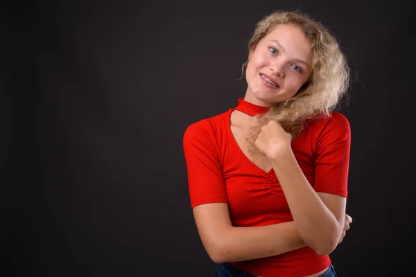 Jovem mulher bonita com cabelo encaracolado loiro contra backgro cinza — Fotografia de Stock