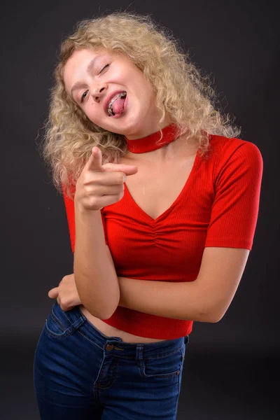 Jovem mulher bonita com cabelo encaracolado loiro contra backgro cinza — Fotografia de Stock