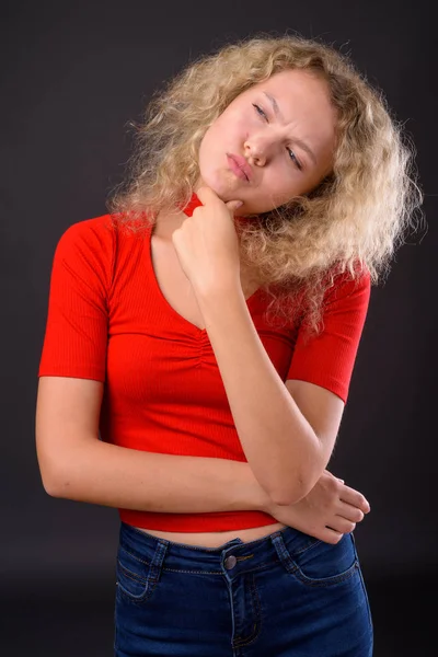 Fiatal gyönyörű nő, a szőke göndör haja, szürke backgro ellen — Stock Fotó
