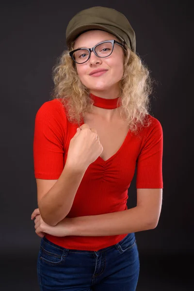 Jovem mulher bonita com cabelo encaracolado loiro contra backgro cinza — Fotografia de Stock