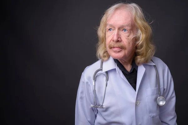 Senior man doctor with mustache against gray background — Stock Photo, Image