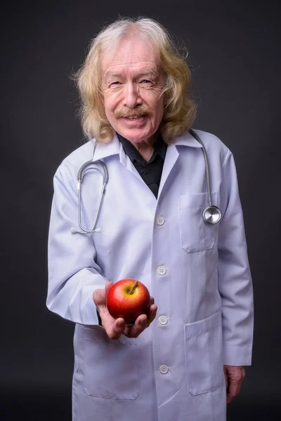Senior uomo medico con i baffi contro sfondo grigio — Foto Stock