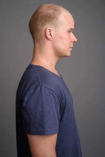 Homem careca usando camisa azul contra fundo cinza — Fotografia de Stock