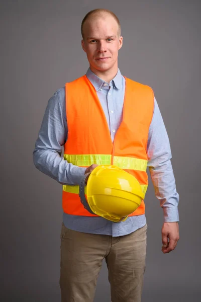 Hombre calvo trabajador de la construcción contra el fondo gris —  Fotos de Stock