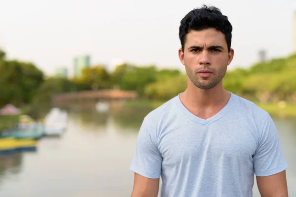 Joven hombre hispano guapo relajándose en el parque — Foto de Stock