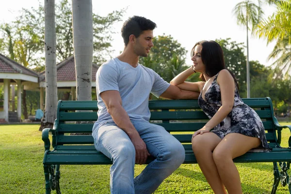 Jovem casal hispânico relaxando no parque juntos — Fotografia de Stock