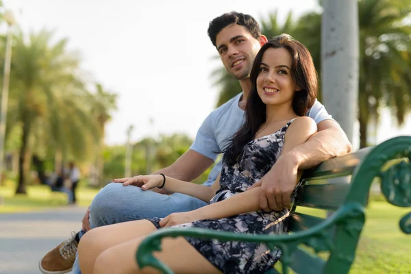 Jovem casal hispânico relaxando no parque juntos — Fotografia de Stock