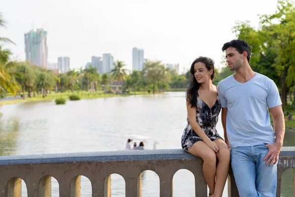 Jovem casal hispânico relaxando no parque juntos — Fotografia de Stock