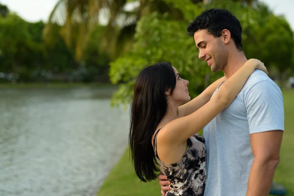 Pareja joven hispana relajándose en el parque juntos —  Fotos de Stock