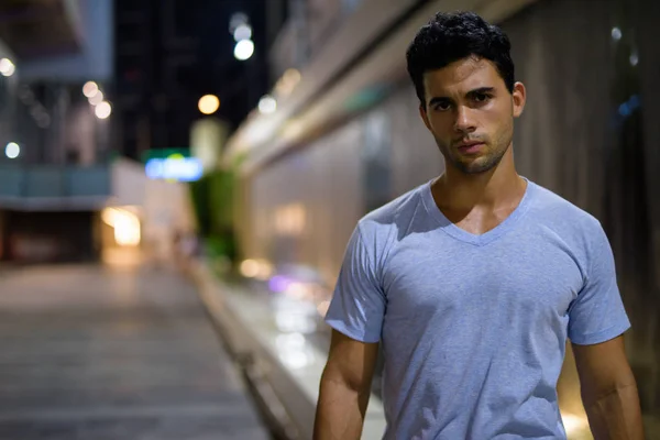 Joven hombre hispano guapo explorando las calles de la ciudad por la noche — Foto de Stock