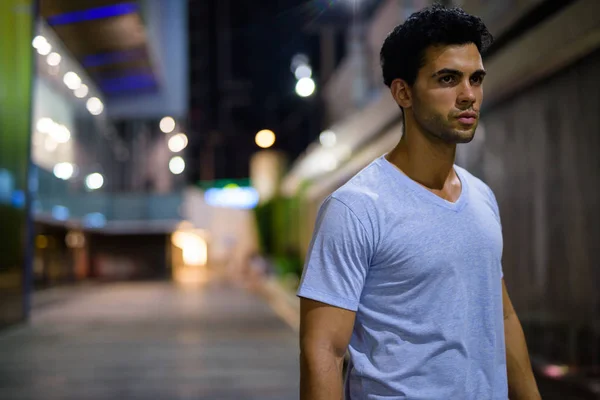 Joven hombre hispano guapo explorando las calles de la ciudad por la noche — Foto de Stock