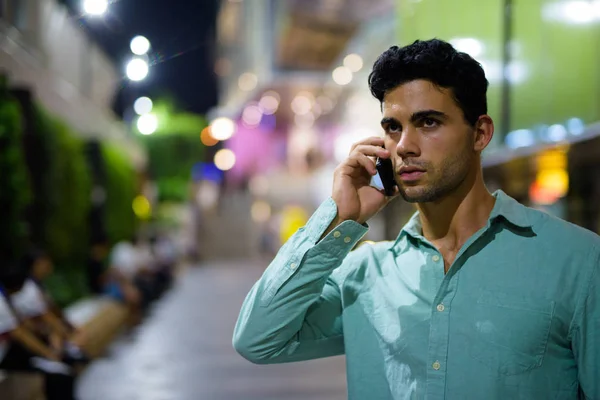 Jeune homme hispanique beau explorant les rues de la ville la nuit — Photo