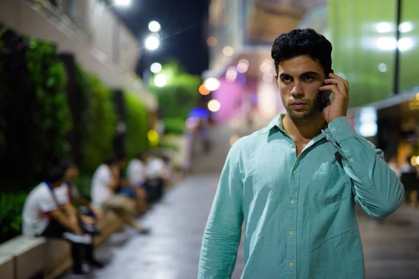 Jeune homme hispanique beau explorant les rues de la ville la nuit — Photo