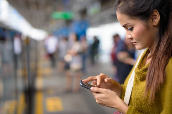 Ung Vacker asiatisk kvinna använder mobiltelefon train station — Stockfoto