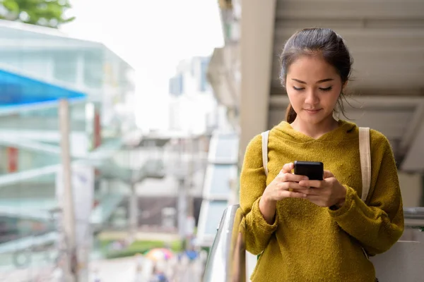 Ung Vacker asiatisk kvinna med mobiltelefon i city — Stockfoto