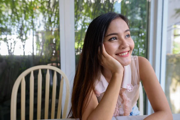 Jonge mooie Aziatische vrouw ontspannen in de coffeeshop — Stockfoto