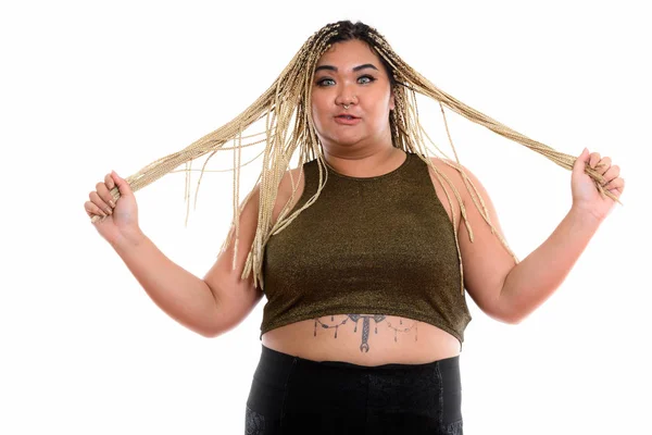 Studio skott av unga fett asiatisk kvinna tag i hennes hår med både — Stockfoto