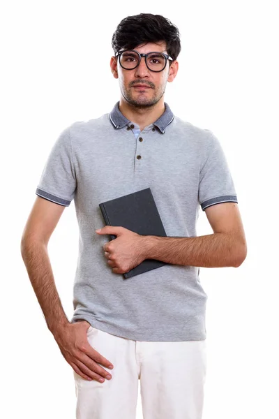 Studio shot of young Persian man holding book — Stock Photo, Image