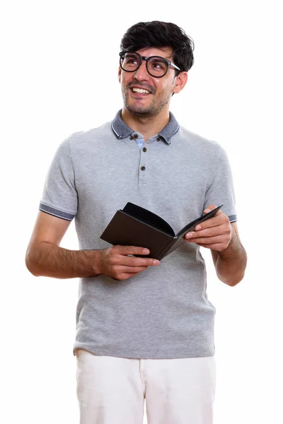 Thoughtful happy Persian man smiling and holding book while and — Stock Photo, Image