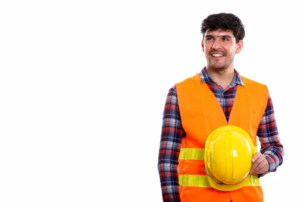Joven feliz hombre persa trabajador de la construcción sonriendo y sosteniendo — Foto de Stock