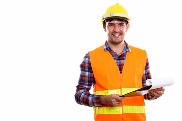 Joven feliz hombre persa trabajador de la construcción sonriendo mientras sostiene —  Fotos de Stock