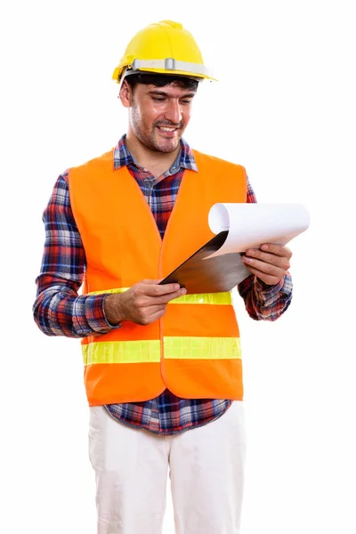 Joven feliz hombre persa trabajador de la construcción sonriendo mientras lee —  Fotos de Stock