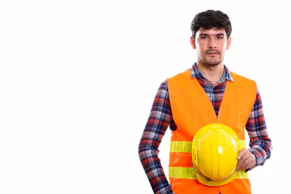 Estúdio tiro de jovem homem persa trabalhador da construção segurando saf — Fotografia de Stock