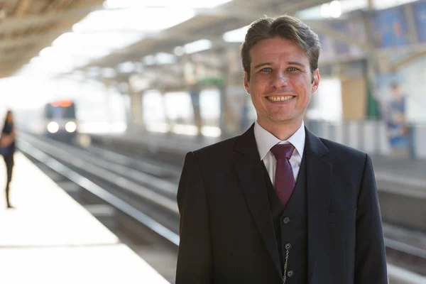 Retrato del hombre de negocios feliz sonriendo en la estación de tren — Foto de Stock