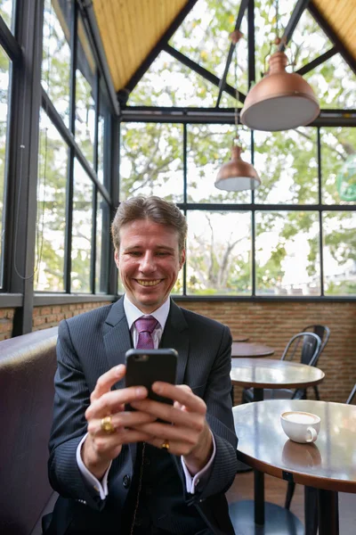 Счастливый Бизнесмен Улыбается Пользуется Мобильным Телефоном Кафе — стоковое фото