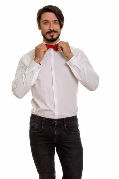 Studio shot of handsome man winking and holding bow tie — Stock Photo, Image